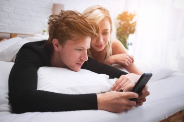 Akıllı telefonlu genç çift dinleniyor. 