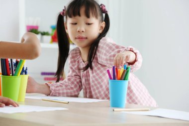 Asyalı okul öncesi öğrenci bir renk çizerek ev ödevi yapmak, bu 