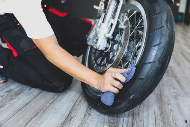 Servis atölyesinde çalışan bir motosiklet çarkı..