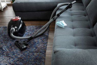 Elektrikli süpürge ve tozu korumak için yüz maskesi ile temizlik. Evi temizlemek için gerekli aletler..