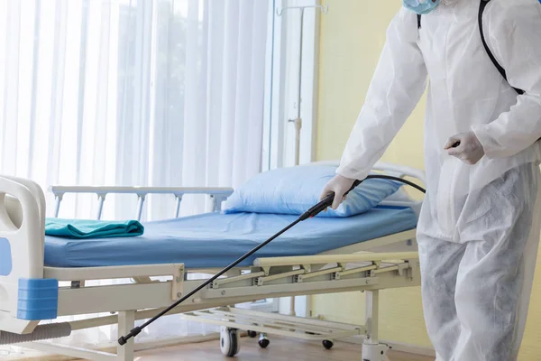 コロナウイルス流行中の病院の部屋での清掃と消毒消毒努力のための専門チーム感染予防と流行の制御保護スーツとマスク ストックフォト