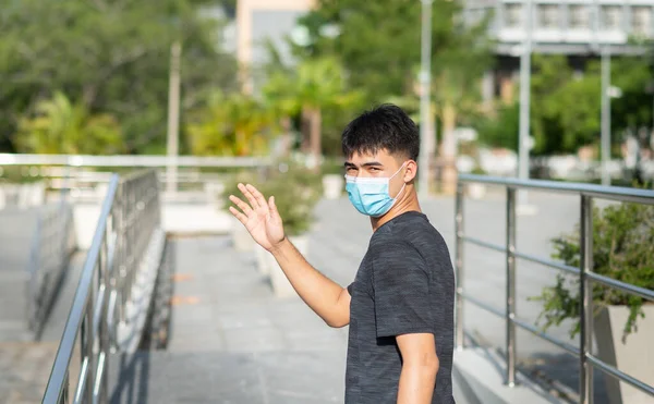 Portrait of young Asian man with face mask to protect and prevent from the spread of viruses in the city during COVID-19 pandemic