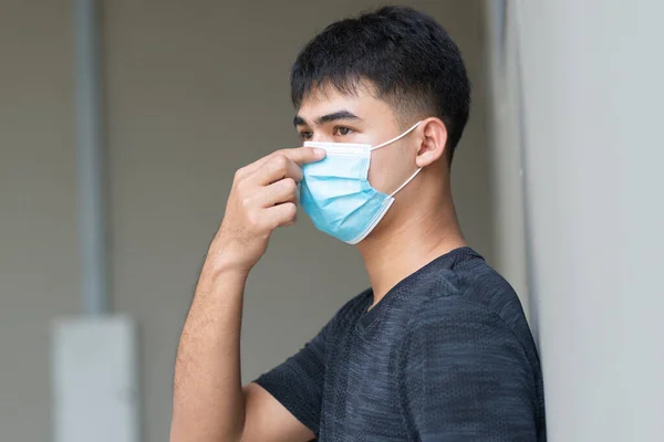 Portrait of young Asian man with face mask to protect and prevent from the spread of viruses at outdoor