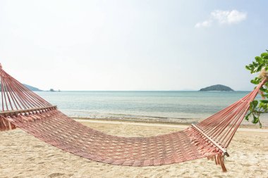 Hamak deniz ve mavi gökyüzü arka plan ile tropik sahilde palm gölgesinde.