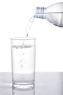 Kırpma yolu olan beyaz arka planda şişeden cama su dökerek.