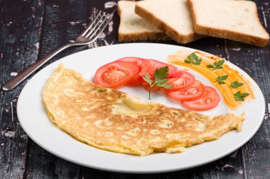peynir ve domates beyaz tabakta ile doldurulmuş omlet