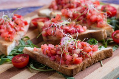 Bruschetta domates fesleğen ve rucola ahşap tahta üzerinde