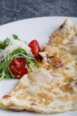 peynir ve domates beyaz tabakta ile doldurulmuş omlet