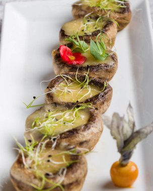 peynir beyaz plaka üzerinde ızgara mantar dolması