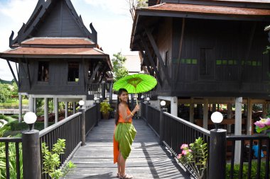 Kanchanaburi, Tayland, 09.09.2019: Geleneksel Tay güzel Tay kız, yeşil şemsiye ve aksesuarları ile Siyam elbise 
