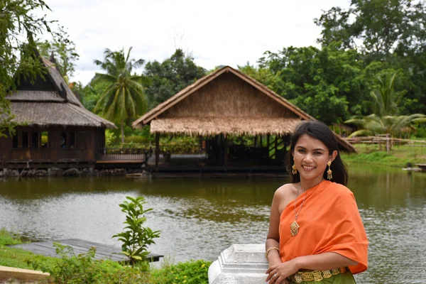 Kanchanaburi, Thailand, 09.09.2019: mooie Thaise meisje in traditionele Thaise, Siamese jurk met groene paraplu en accessoires in "Mallika City R.E. 124" een erfgoed, retro Siamese dorp — Stockfoto