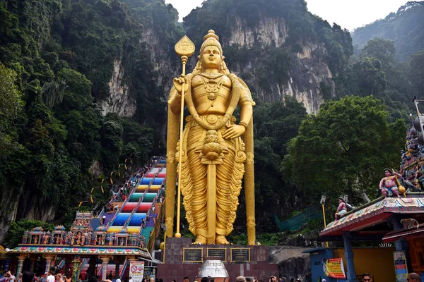 Entrada a las cuevas de Batu con la estatua gigante y dorada de Murugan y la escalera colorida de 272 escalones — Foto de Stock