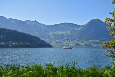 Lucerne Gölü 'nde yüzen buharlı teknenin manzarası muhteşem Pilatus Dağı ve arka planda vadiler. 