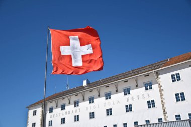 ARTH, SWITZERLAND - SEPTEMBER 29, 2019 : Facade of Rigi Kulm Hotel and Restaurant with Swiss flag at top of Rigi Kulm, Mount Rigi in Switzerland  clipart