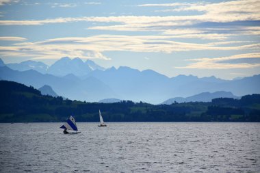 Zug Gölü manzarası. Arka planda Rooterberg 'in su üzerinde yüzen kanoları ve dağ sıraları var. 