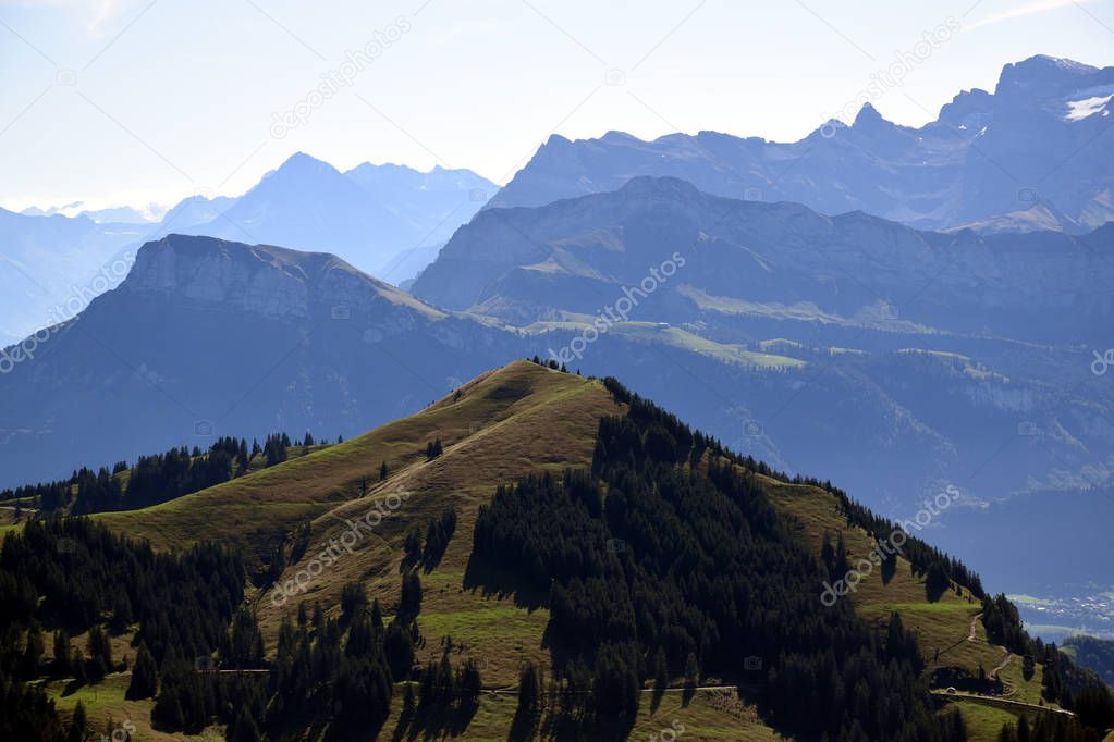 Panoramic landscape view of meadows and mountain ranges with snowy mountain peaks from top of Rigi Kulm, Mount Rigi in Switzerland 