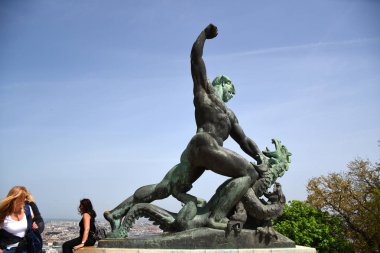 Budapeşte, Macaristan, 04.24.2019: Macaristan 'ın Budapeşte kentindeki Geller Tepesi' nin tepesinde yer alan Kale Özgürlük Heykeli 'nin (kale, bir tür kale) sağındaki bronz ejderha öldüren sağ figürü