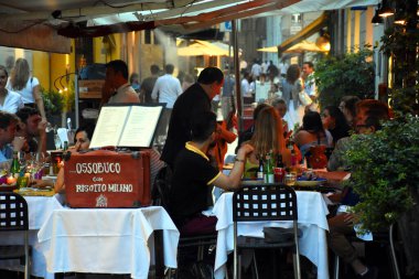 Milan, İtalya, 08.04.2019: Milano 'nun Brera Sanat Bölgesi' nin güzel, romantik sokaklarındaki geleneksel bir İtalyan restoranında aperatifin tadını çıkaran insanlar