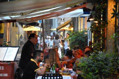 Milan, İtalya, 08.04.2019: Milano 'nun Brera Sanat Bölgesi' nin güzel, romantik sokaklarındaki geleneksel bir İtalyan restoranında aperatifin tadını çıkaran insanlar