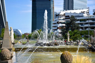 Milano, Italy, 14.07.2019: Fountain of The Four Seasons at Piazzale Giulio Cesare, with the Three Towers, Tre Torri  clipart
