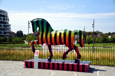 Milano, Italy, 14.07.2019: Colorful horse sculpture by Marcelo Burlon in honor of the magnificent Leonardo da Vinci at the bottom, next to the entrance of Generali Tower, Lo Storto/The Twisted One