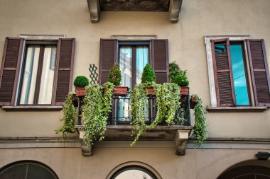 Milan, İtalya 05.12.2020: Üzerinde yeşil bitkiler bulunan eski bir İtalyan balkonu