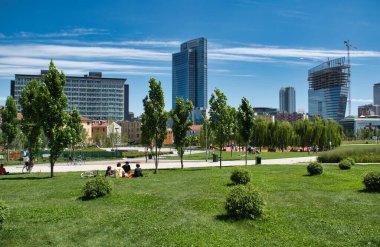 Milan, İtalya 06.20.2020: Milano 'daki yeni Ağaç Kütüphanesi parkının çimlerine boyanmış ve güneşten keyif alan insanlar