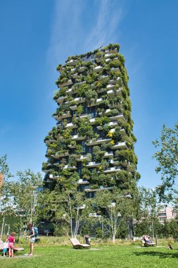Milan, İtalya 06.20.2020: Milano 'daki Bosco Verticale Dikey Orman binasının önündeki yeni Ağaç Kütüphanesi parkında güneşli yataklarda güneşlenen insanlar