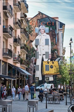 Milan, İtalya 06.20.2020: Corso Como 'da yürüyen ve öğle yemeği yiyen insanlar, arka planda büyük bir Gucci duvar reklamı ile sosyal uzaklık şartlarına uygun olarak