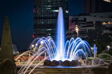 Milano, İtalya, 12.08.2020: Dört Mevsimin Renkli, çarpıcı Çeşmesi, Fontana delle Quattro Stagioni Jül Sezar Meydanı 'nda, Piazzale Giulio Cesare gece boyunca. Uzun pozlu fotoğrafçılık
