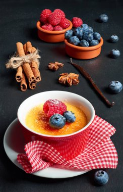Krem brulee (krem brulee, yanık krem) ahududu ve mavi ile