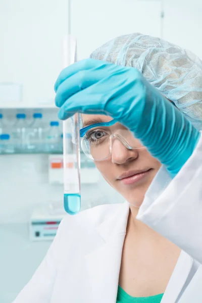 Jovem cientista ou tecnologia feminina com amostra líquida no tubo de ensaio — Fotografia de Stock