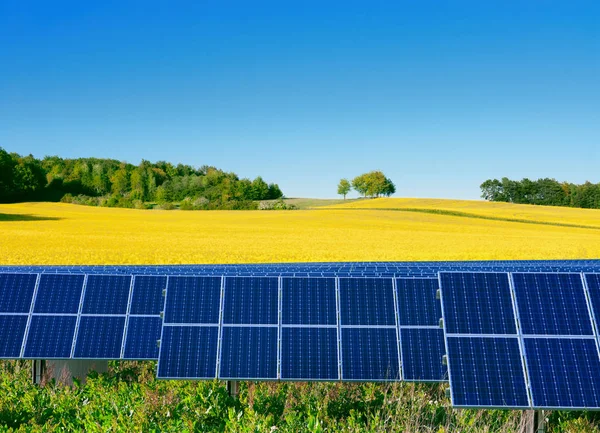 Solarzellen mit einem Rapsfeld als Hintergrund — Stockfoto