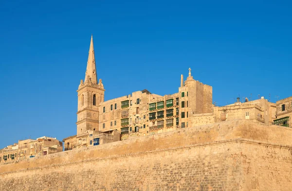 Een oude zandstenen kerk en huizen in Valetta, Malta — Stockfoto