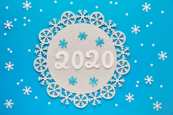 Snowflakes and paper number 2020 on blue pastel paper, New Year background — Stock Photo, Image