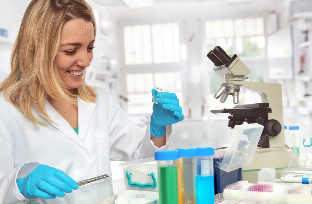 Female scientist in lab coat and protective gloves