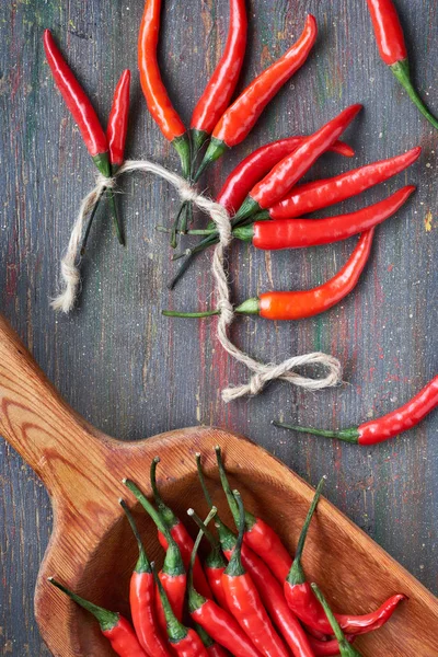 Detailní záběr na červené pálivé chilli papričky na tmavém dřevě, ploché ležel — Stock fotografie