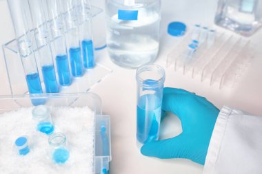 Eldivenli dişi elde sıvı numunesi, glas mavi sıvı örnekleri