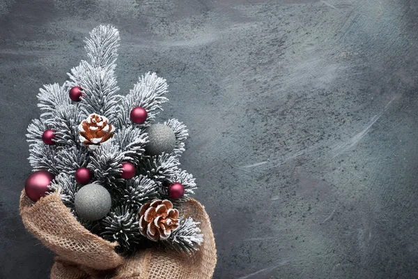 Small Christmas tree in sackcloth decorated with red baubles and — 스톡 사진