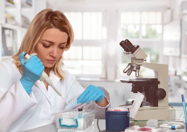 Jovem tecnologia feminina ou cientista carrega amostra líquida na banheira de teste — Fotografia de Stock