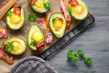 Fırında pişmiş avokado tekneleri, yumurta ve pastırmayla birlikte.