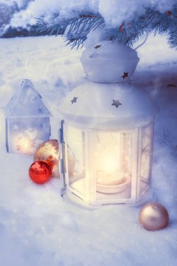 Dışarıda, kar altında bir Noel ağacında küçük kış fenerleri..