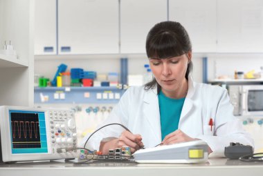 Genç bayan teknisyen ya da mühendis elektronik ekipman onarıyor