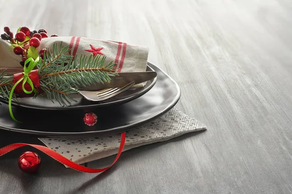 Christmas menu concept with decorated black plates and cutlery — Stock Photo, Image