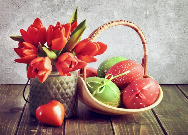 Páscoa ainda vida com tulipas vermelhas, presente embrulhado e ovos de Páscoa — Fotografia de Stock