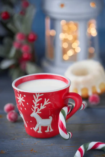 Closeup on red cup of milk with Christmas deer design, bundt cak — Stock Photo, Image