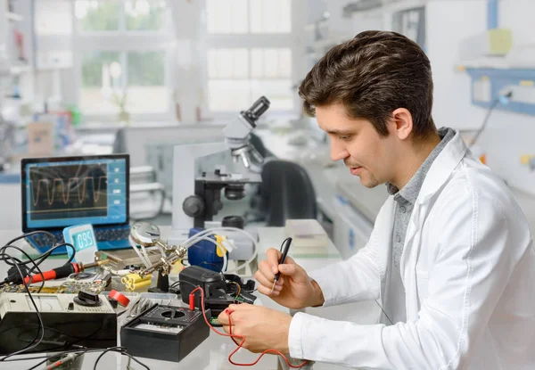 Młody technik lub inżynier naprawia sprzęt elektroniczny — Zdjęcie stockowe