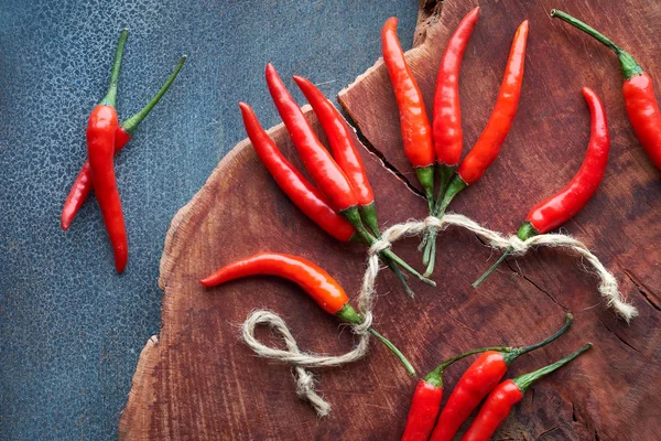 Close-up op rode hete chili pepers op donker hout, plat gelegd — Stockfoto