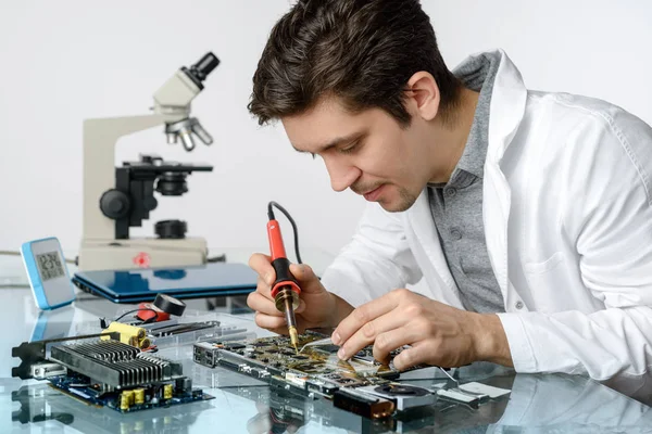 Молодий енергійний чоловічий технік або інженер ремонтує електронне обладнання — стокове фото