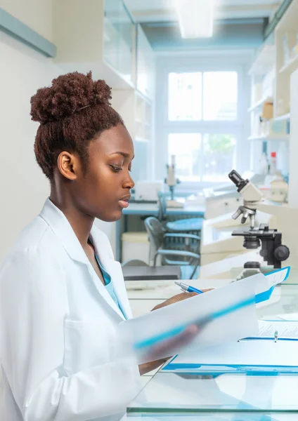Молодая африканская женщина-биолог работает в лаборатории — стоковое фото